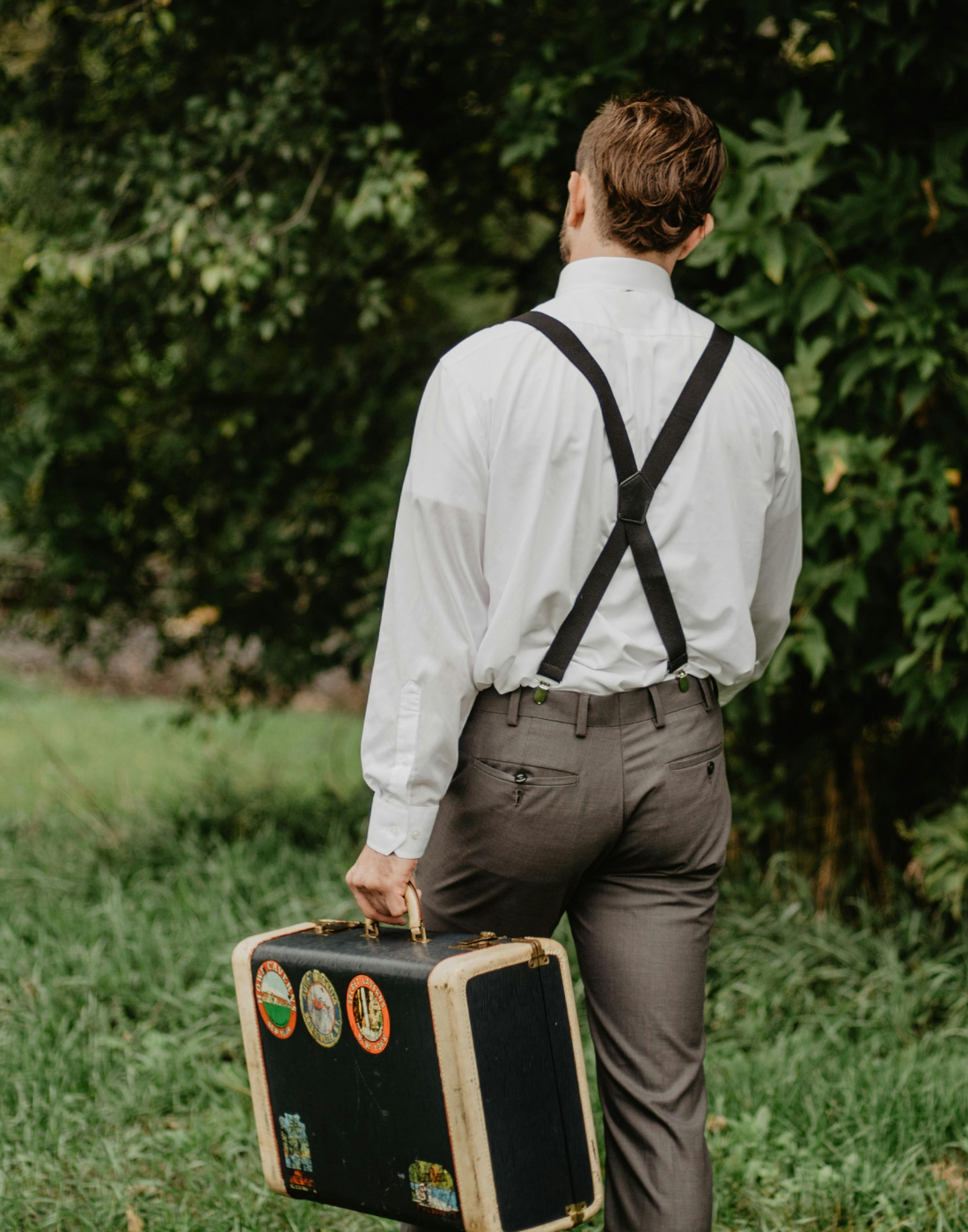 Ein Mann, von hinten zu sehen, während er in schwarzen Hosenträgern in X-Form mit stabilen Clips unterwegs ist.