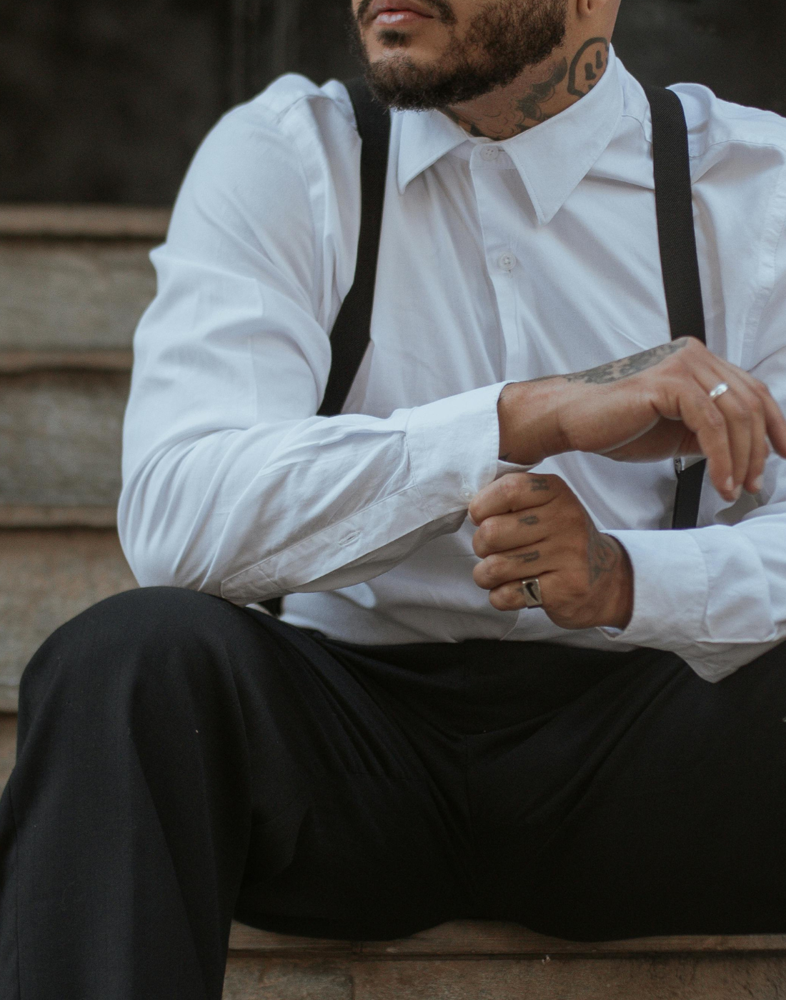 tatoowierter mann mit schwarzen hosenträger